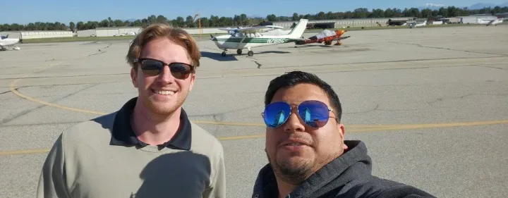 Student pilot and Certified Flight Instructor celebrating on the ramp after a successful training flight